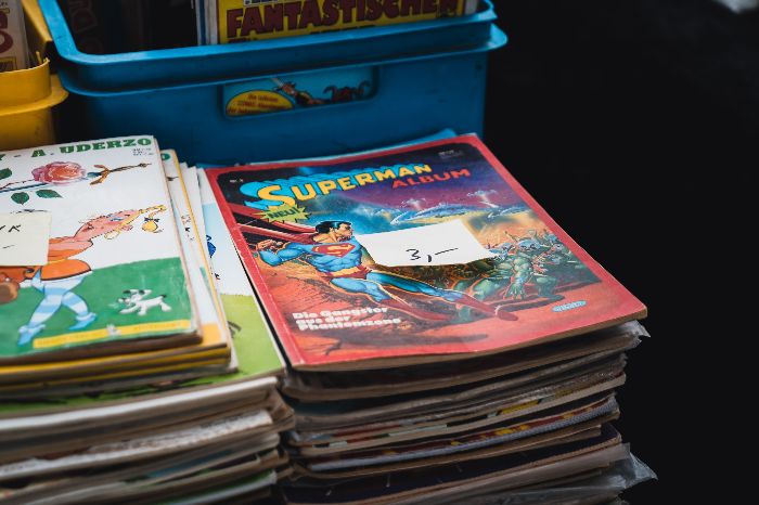 various old comic books stacked on top of each other with price tags displayed